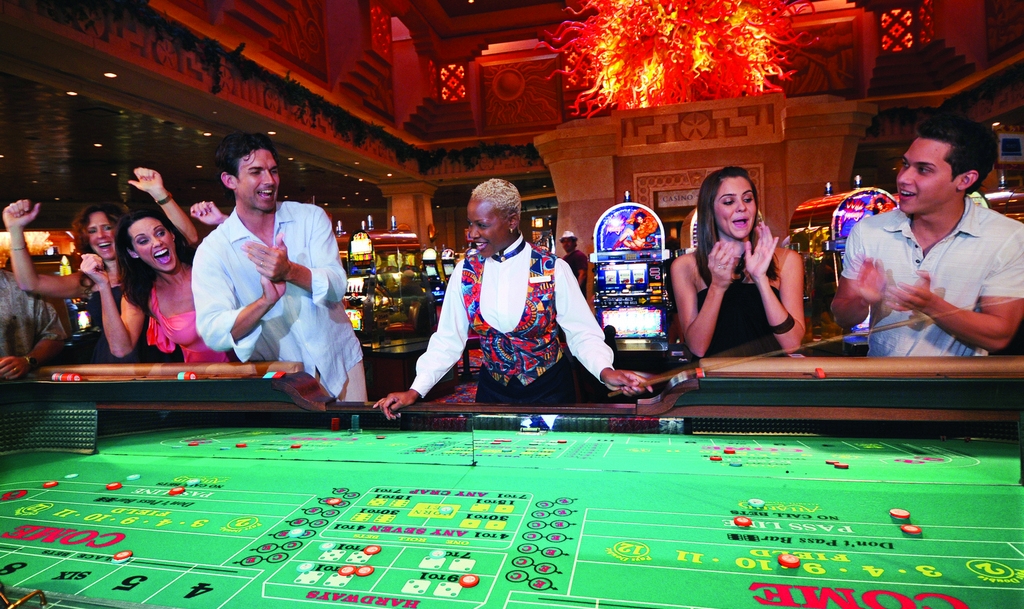 Люди разных национальностей радостно аплодируют стоя у стола для крэпса