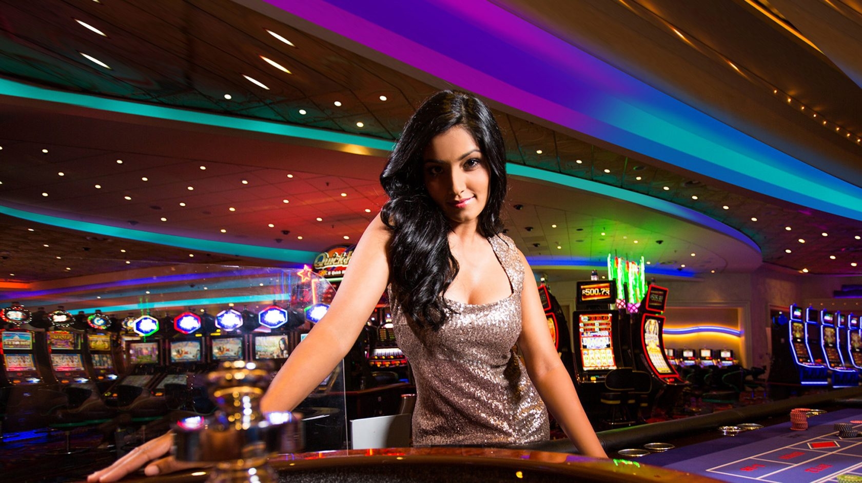 Стройная брюнетка в обтягивающем платье позирует у колеса рулетки