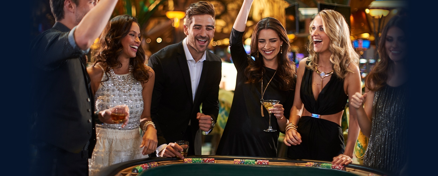 Двое богатых мужчин развлекаются в казино в компании красоток модельной внешности