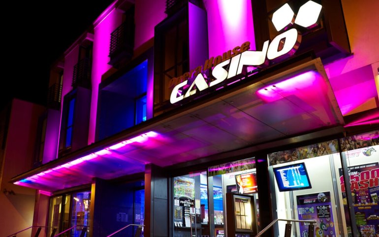 Яркий фасад с фиолетовой вывеской казино The Opera House Casino в Ангии