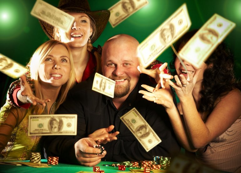 Обеспеченный мужчина развлекается в казино в компании красоток, а сверху летят стодолларовые купюры