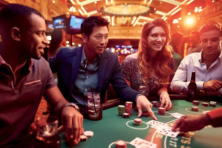 Европей2цы, темнокожий парень и азиат ведут игру в блэкджек в казино на курорте