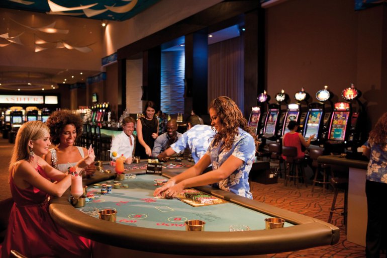 Элегантно одетые люди проводят время за игрой в казино, а дилеры активно работают с клиентами