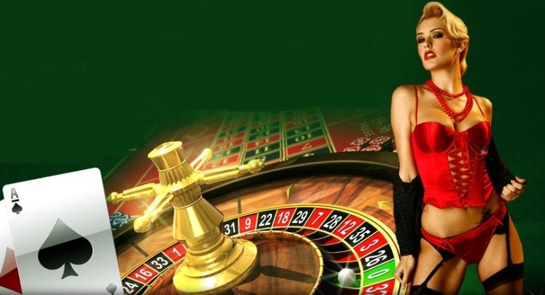 Сексуальная блондинка в красном атласном боди и чулках в сетку позирует на зеленом фоне, а рядом колесо рулетки и поле для ставок