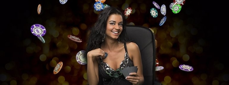 Сексуальная мулатка в красивом платье сидит за игорным столом с картами в руках, а вокруг летают фишки казино