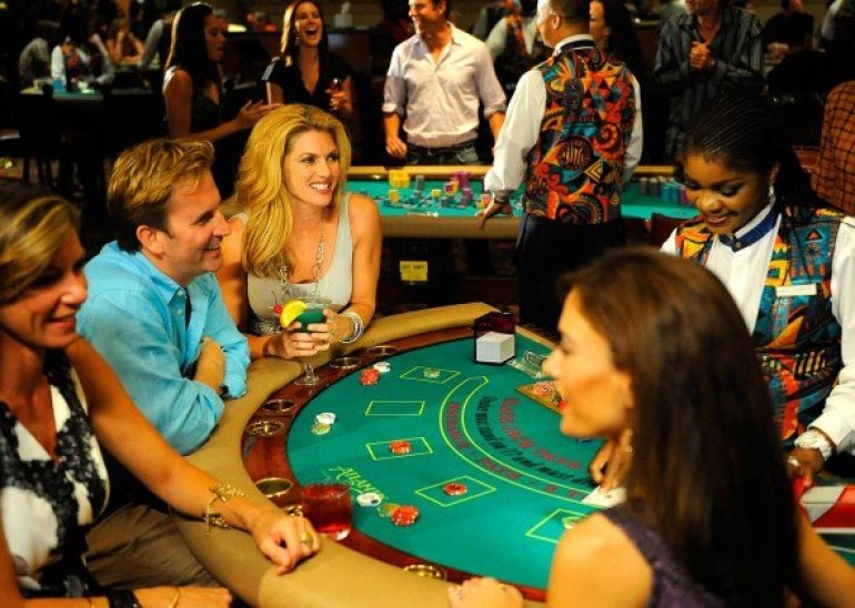 Темнокожая девушка крупье ведет игру в блэкджек для элитного общества в казино