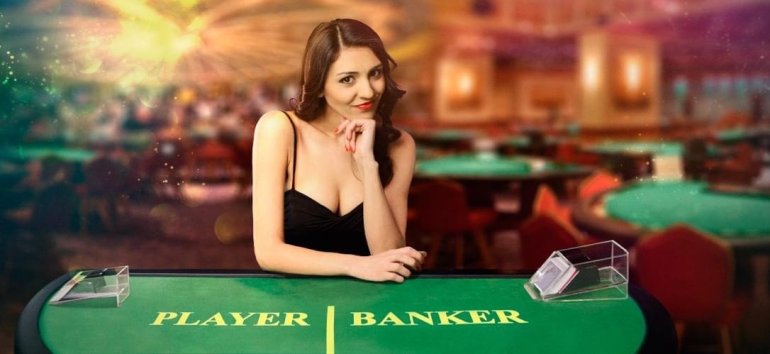 Сексуальная девушка крупье в коктейльном платье с глубоким декольте позирует за столом для игры в баккара