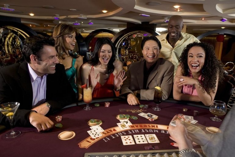 Азиаты и европейцы распивают коктейли и веселятся за игрой в казино