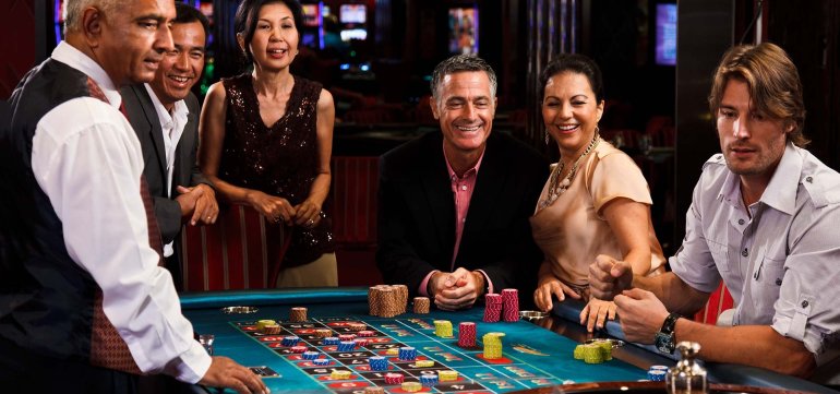 Не молодой дилер ведет игру в рулетку для гостей казино