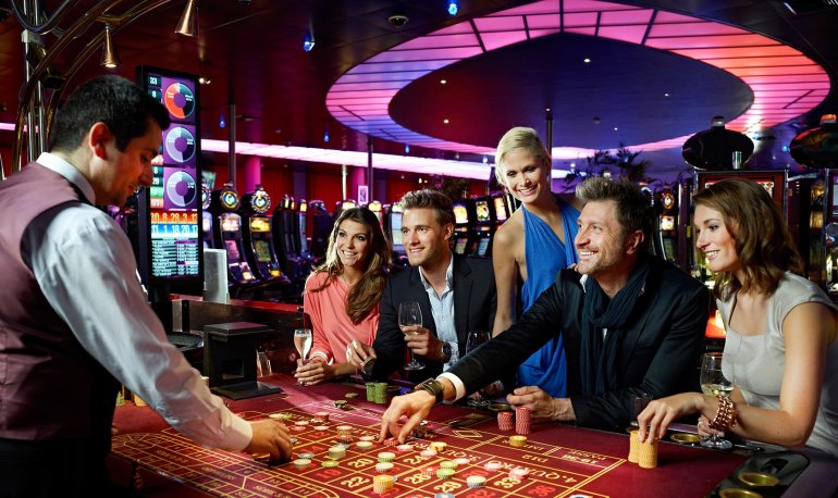 Мужчина крупье ведет игру в рулетку для элитных клиентов казино