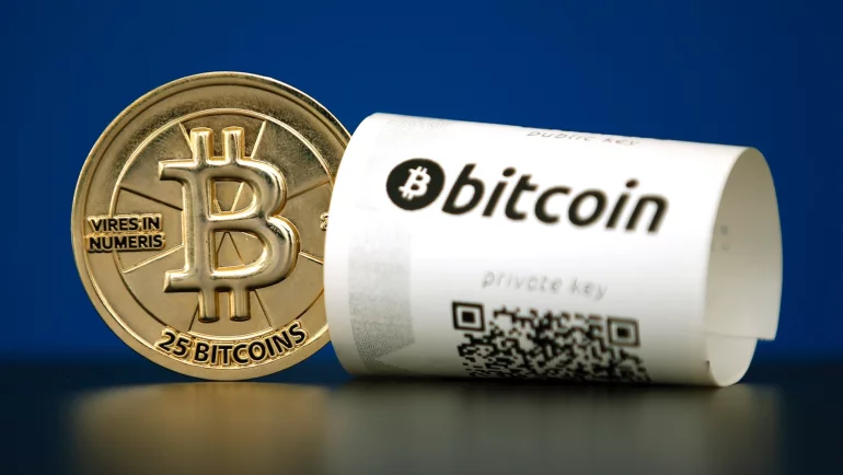 Монета Биткоин, а рядом чек этой платежной системы