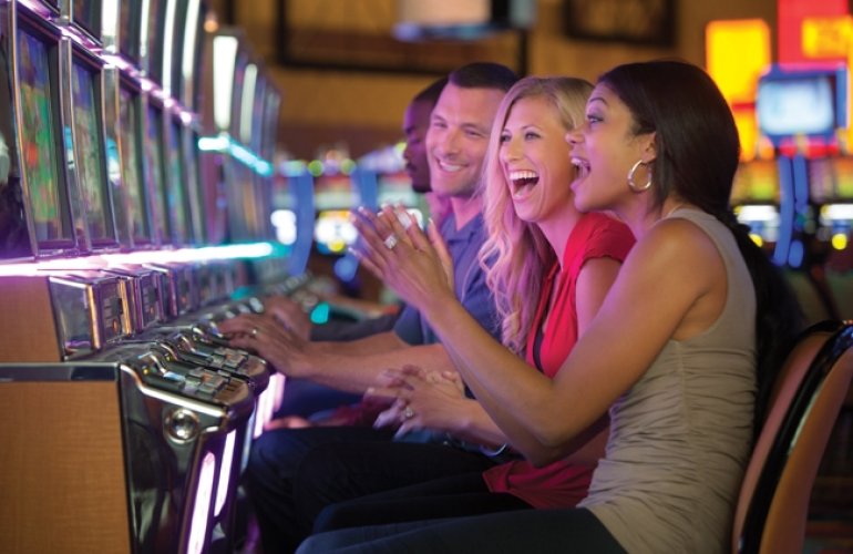 Женщины кричат от восторга, увидев на экране игрового автомата выигрыш джек-пота