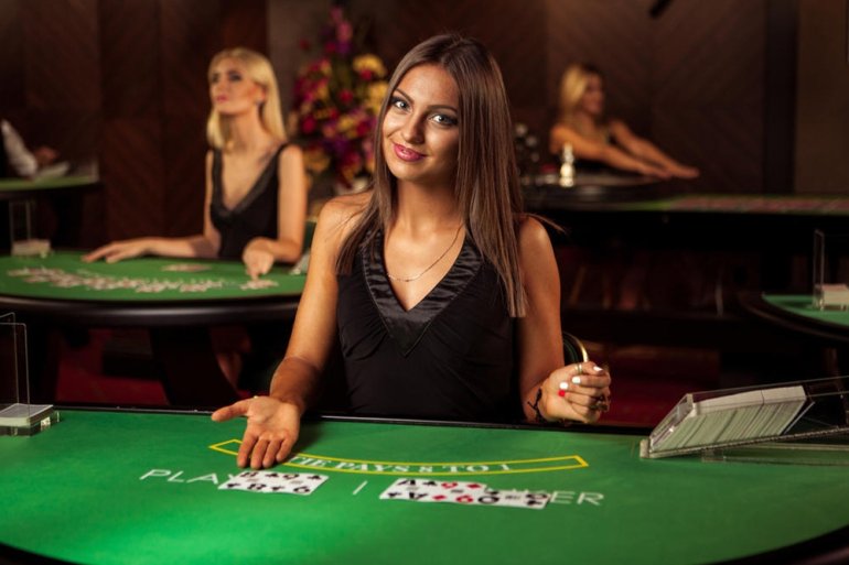 Приветливая русоволосая девушка крупье ждет вас в казино за столом для покера