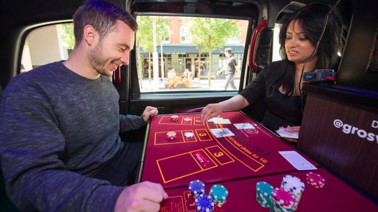 Мужчина играет в покер в мини-казино в такси в Лондоне