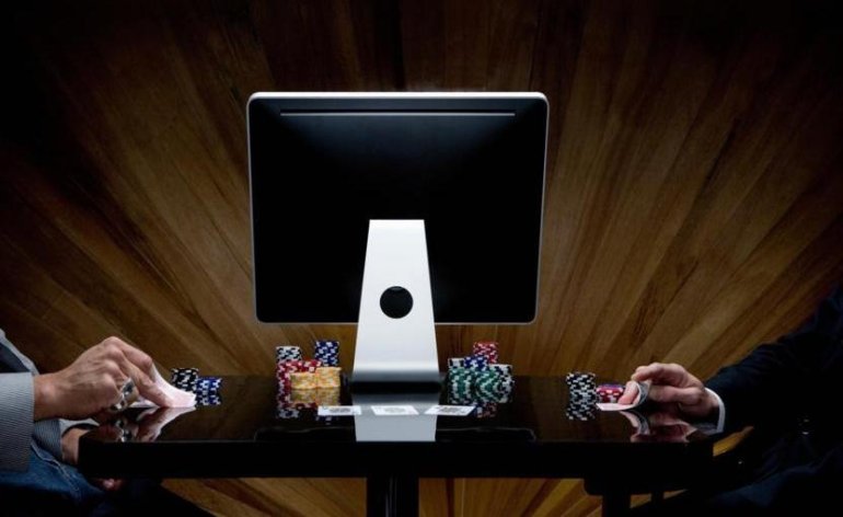 Двое незнакомцев играют в покер по две стороны от монитора компьютера