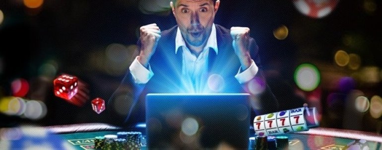 Мужчина радуется своей победе в онлайн казино, сидя перед монитором компьютера