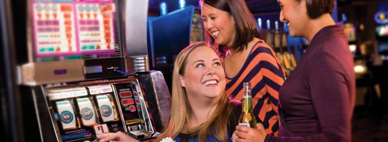 Три азартные подруги советуются прежде, чем совершить ставку на игровом автомате