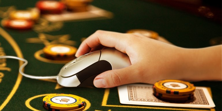 Компьютерная мышка рядом с фишками на столе в казино